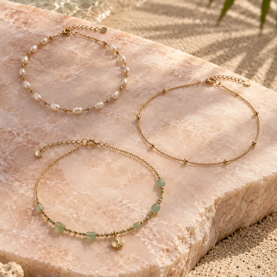 Three delicate gold-tone anklets with pearl and pale green details